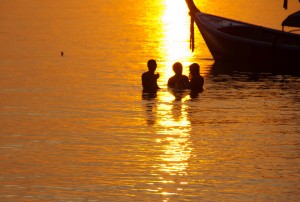 Photo de gens en train de se baigner à l'heure du coucher de soleil